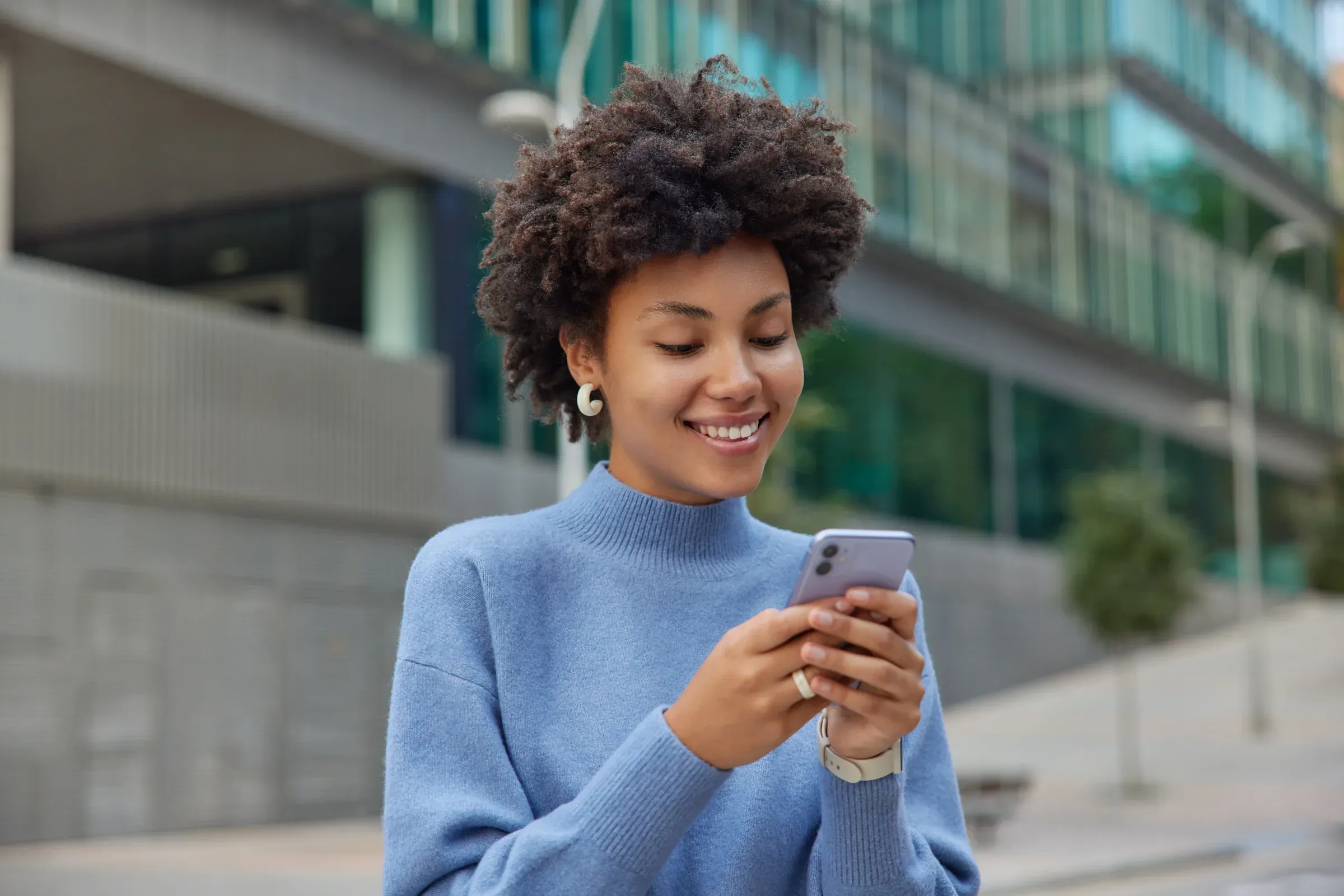 Ofis binasının önünde telefonunu kontrol eden bir kadın